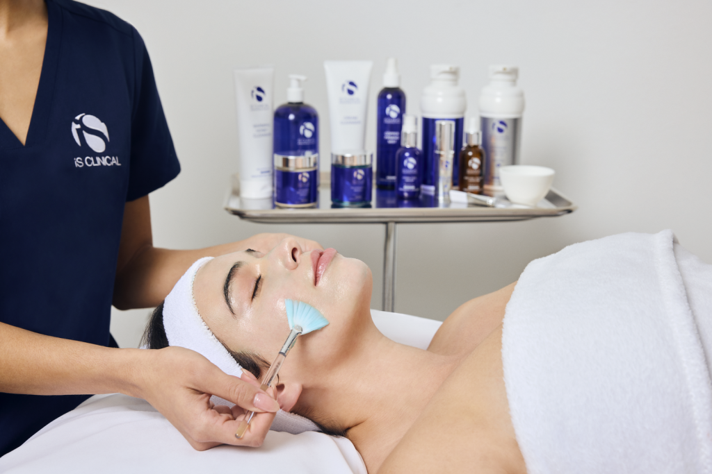 Esthetician applying mask on clients face for Fire & Ice Facial Treatment