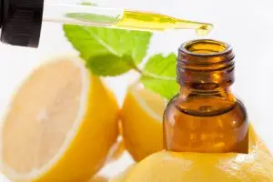 Bottle of lemon essential oil with lemons