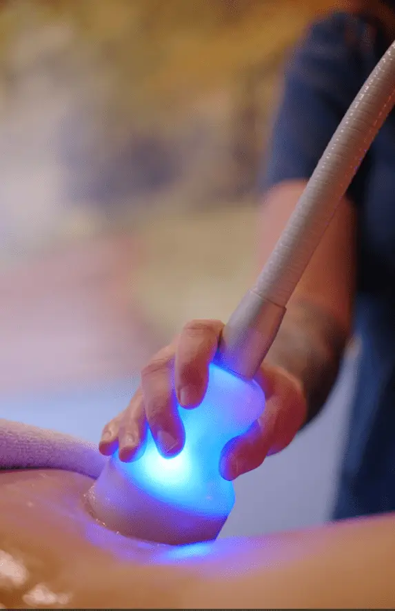 Spa therapist administers cryotherapy for cellulite and fat reduction.