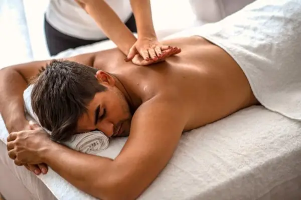 Professional massage center providing therapy to release man's shoulder tension