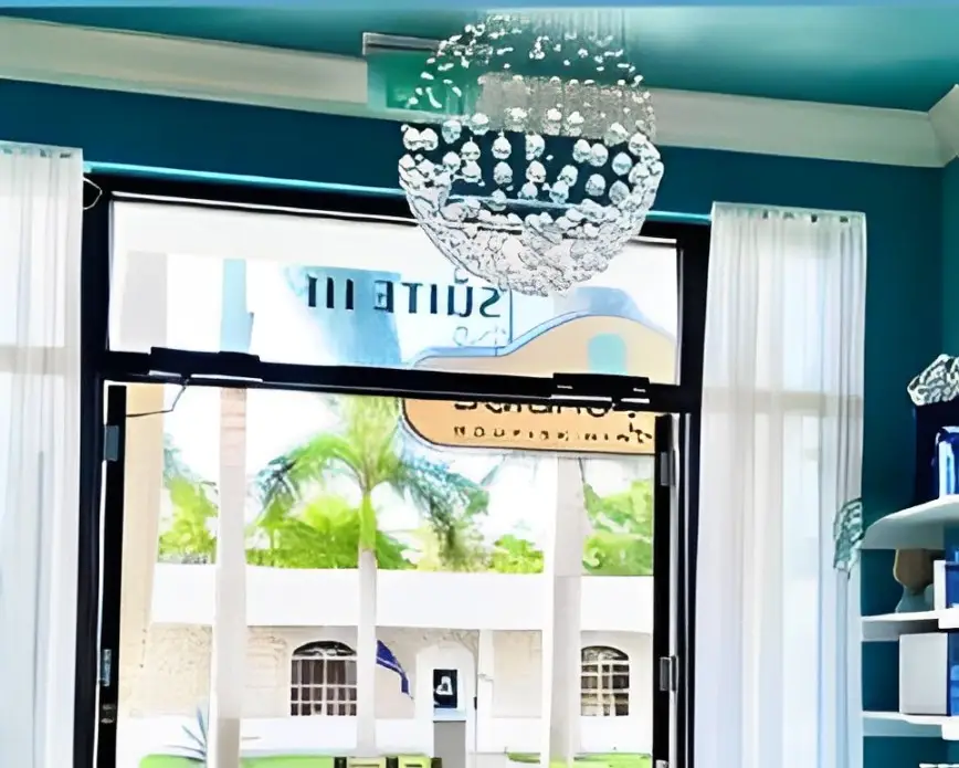 Waiting room with seats, water, and beach imagery at Balance Spa Boca Raton.