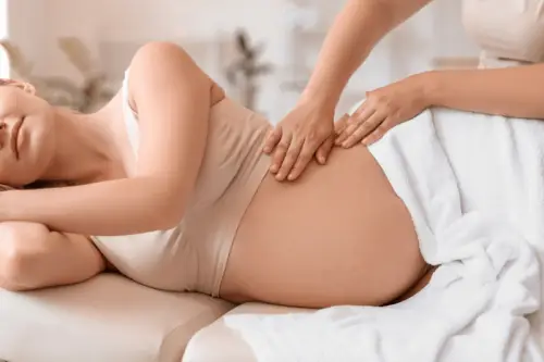 Pregnant woman receiving prenatal massage spa service
