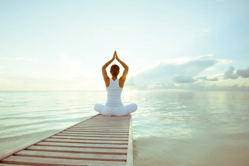 woman on a pier doing yoga